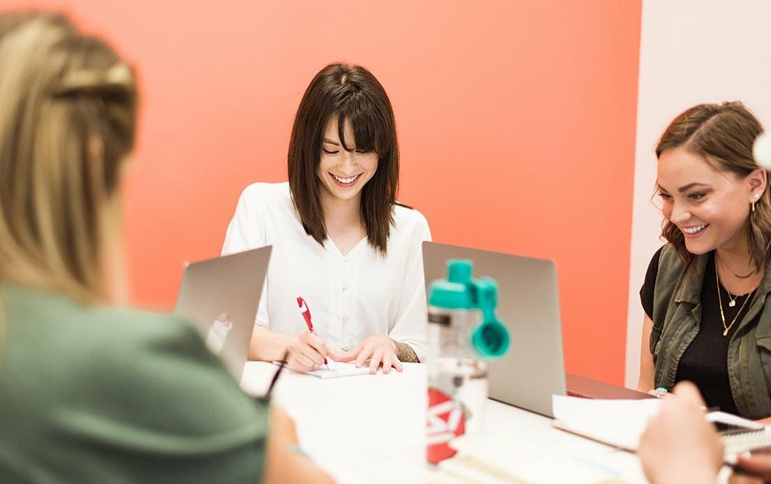 Three colleagues collaborating in a vibrant office setting.