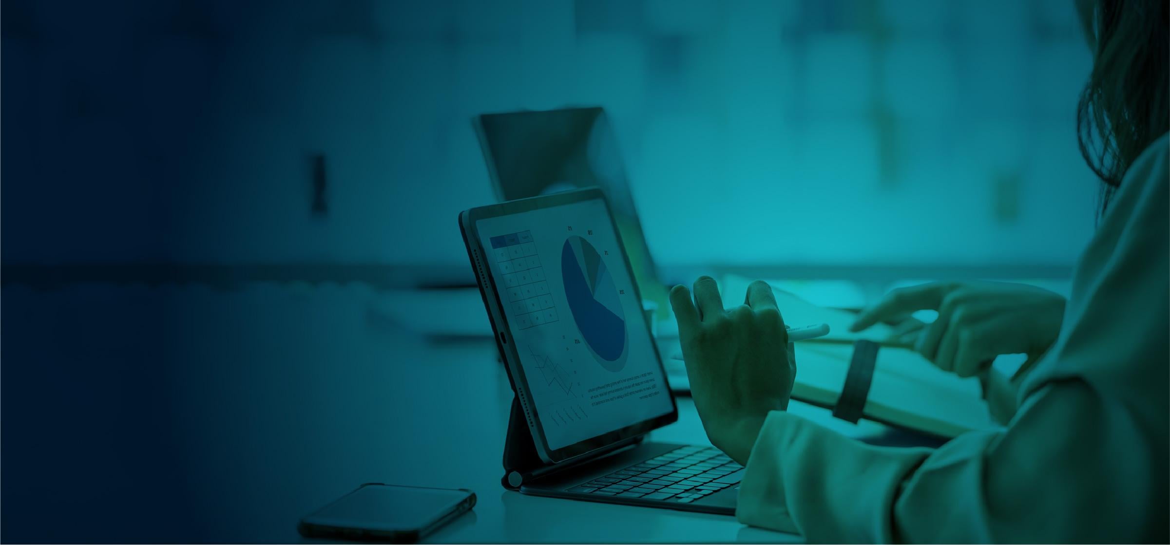 Professional reviewing data on a tablet in an office setting.
